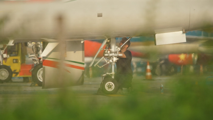 Kỹ sư kiểm tra hệ thống trục bánh đỗ của máy bay.