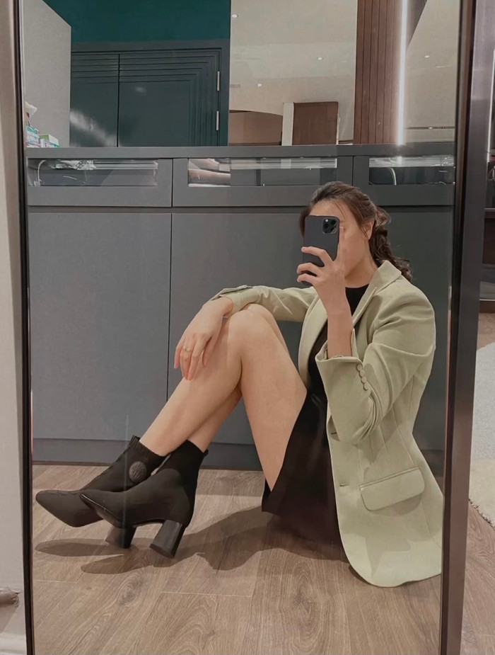 Và cả trước gương với váy ngắn màu đen cùng áo blazer màu xanh khoác ngoài.