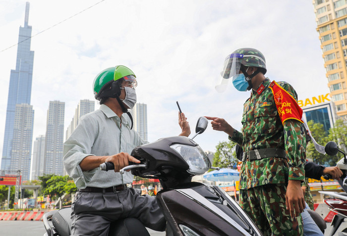 Người dân trình mã QR khi khai 'di chuyển nội địa' tại chốt kiểm soát ở quận Bình Thạnh ngày 30/8. Ảnh: Quỳnh Trần/VnExpress