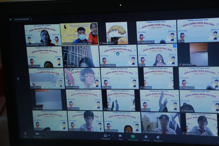 Các em học sinh mặc áo đồng phục trắng, đeo khăn quàng đỏ háo hức trong ngày khai giảng đặc biệt