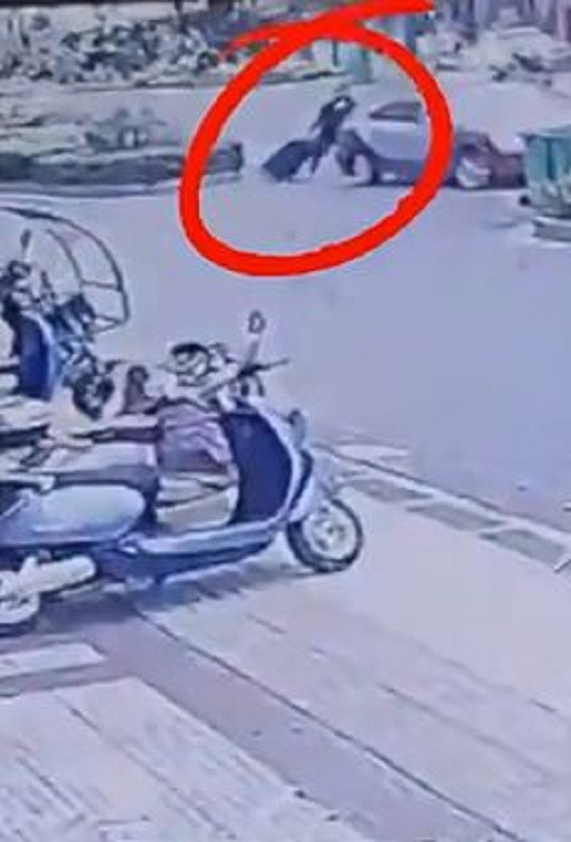 Người đàn ông khệ nệ kéo vali lên xe taxi. 