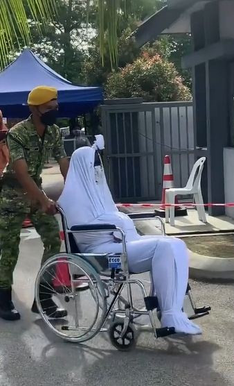 'Thây ma' được một người đẩy xe lăn vào trung tâm tiêm chủng. 