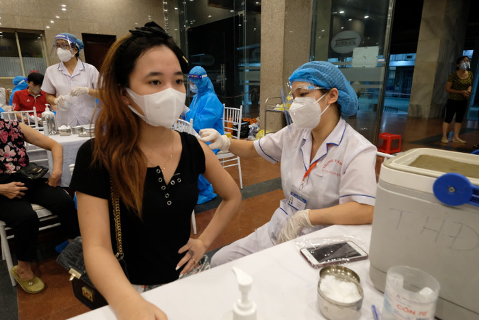 Khi đi tiêm lưu ý những chỗ đông người thì phải ngồi giãn ra, giữ khoảng cách. (Ảnh minh hoạ).