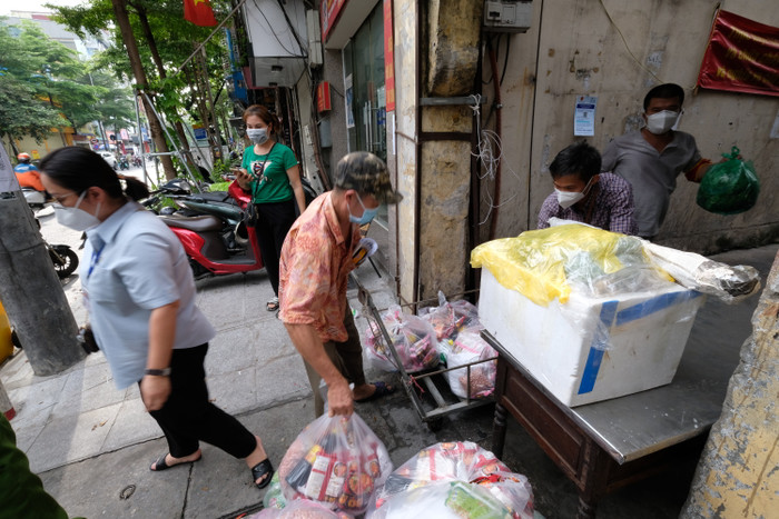 Nhu yếu phẩm được xếp lên bàn trung gian và vận chuyển vào trong.