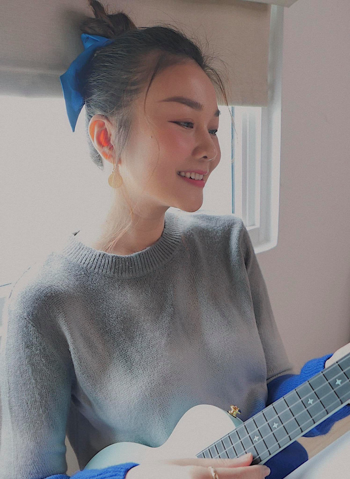 Hình ảnh mới nhất của Thanh Hằng khi cô mặc áo len tay dài ngồi đánh đàn Ukulele