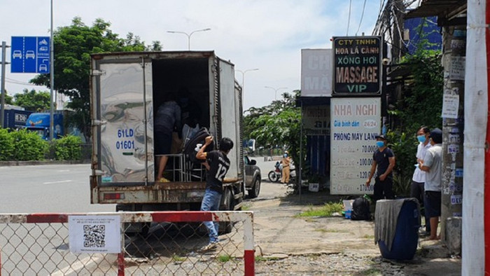 Các F0 đã khỏi bệnh đang chuyển đồ xuống để công an địa phương điều xe đến chở về. Ảnh Tiền Phong