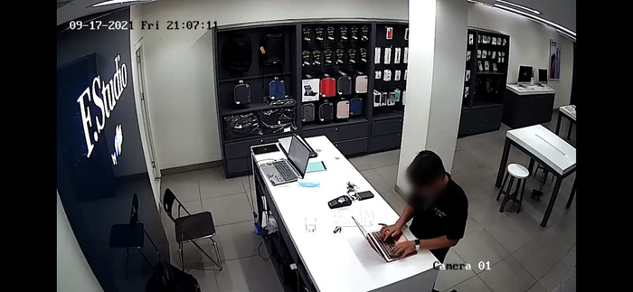 Hình ảnh nam nhân viên thao tác trên máy tính của khách hàng được camera an ninh ghi lại.