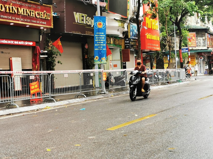 Lực lượng chức năng đã tiến hành phong toả từ số nhà 11 đến số nhà 21 phố Trần Nhân Tông sau khi phát hiện ca dương tính mới. (Ảnh: Tường Bách).