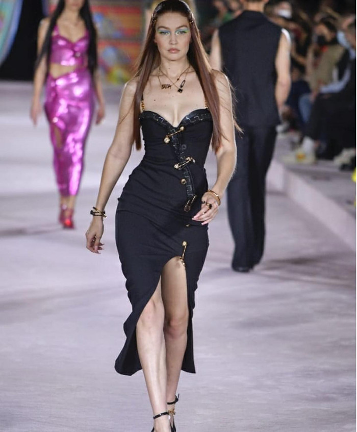 Trong look thứ 2 trên sàn runway, bà mẹ 1 con xinh đẹp mặc bộ váy đen kim băng đặc trưng của Versace hở 'điểm vàng' tuyệt đẹp