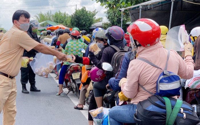 Ấm lòng hình ảnh CSGT tặng bánh mì cho đoàn người đi xe máy về quê Ảnh 2