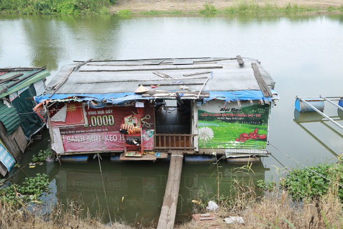 Chiếc 'cầu' vào nhà cậu bé Tùng Linh như sắp gãy, căn nhà bè cũng rất sập xệ.