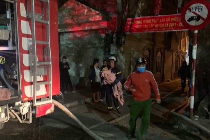 Lực lượng chức năng đưa cháu bé ra khỏi đám cháy. Ảnh Công an Hải Phòng