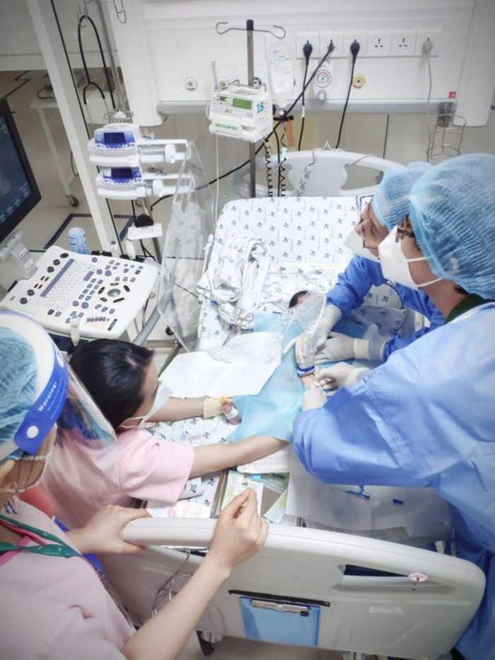 Các y bác sĩ thăm khám cho một bệnh nhi sốt siêu vi. (Ảnh: BV Nhi đồng TP HCM).