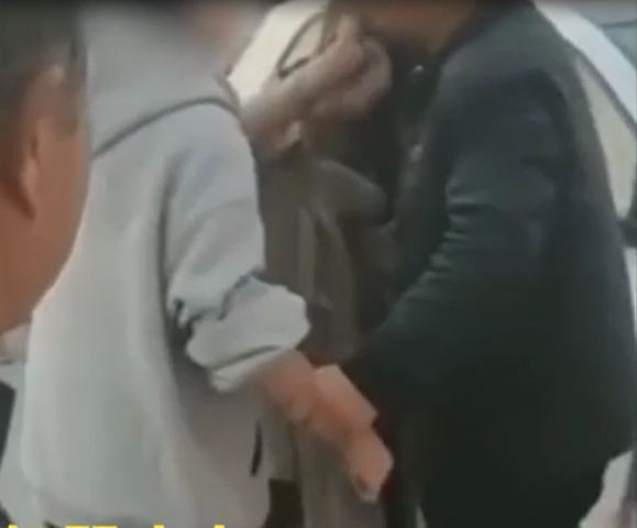 Người vợ bị chồng túm tay cản lại. 