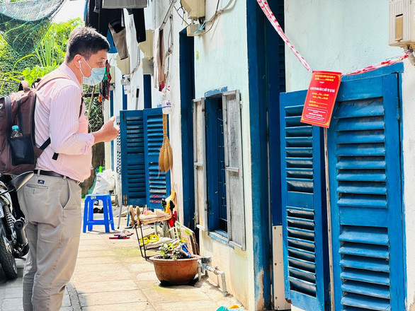 Cán bộ ngành chức năng đi kiểm tra các hộ dân đang thực hiện cách ly tại nhà. Ảnh: HCDC