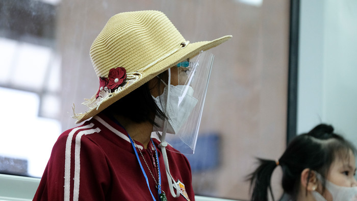 Nhiều người đeo kính chắn giọt bắn khi đi tàu để chống dịch.