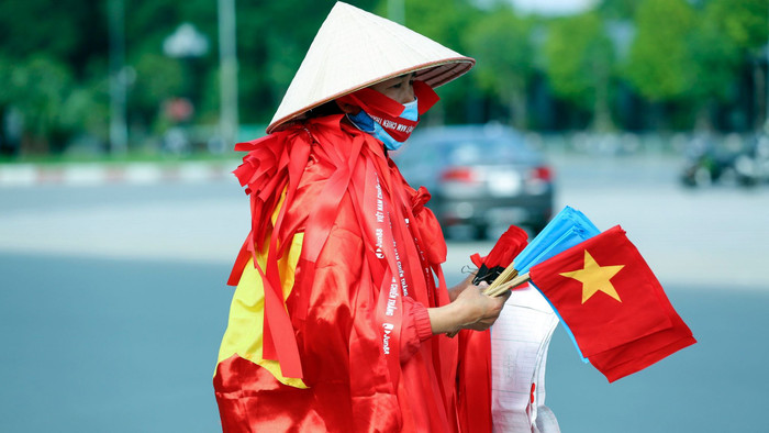 Một số người dân địa phương tranh thủ trận Việt Nam vs Nhật Bản bán cờ, áo đấu trước khi trận đấu diễn ra.