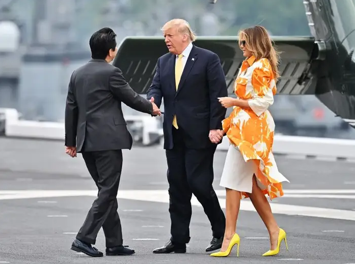 Đôi giày Louboutins của bà Melania và cà vạt của ông Trump có màu giống hệt nhau. Họ đến thăm Nhật Bản vào tháng 5 năm 2019. Theo Yahoo! News, Chiếc áo khoác màu cam của Melania được thiết kế bởi Dries Van Noten.