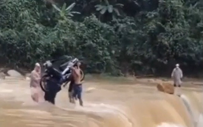 Xôn xao clip 4 người đàn ông khiêng chiếc xe máy vượt dòng lũ dữ chảy xiết Ảnh 2