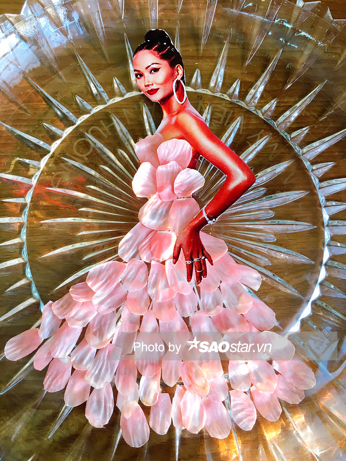 Mẫu thiết kế giúp H'Hen Niê hóa nàng tiên cá, nổi bật trong nắng. Nguyên liệu làm ra chiếc váy này là vỏ của múi bưởi đào. Màu hồng thạch anh tự nhiên, lấp lánh và bắt sáng tựa như lớp xà cừ rất đẹp mắt.