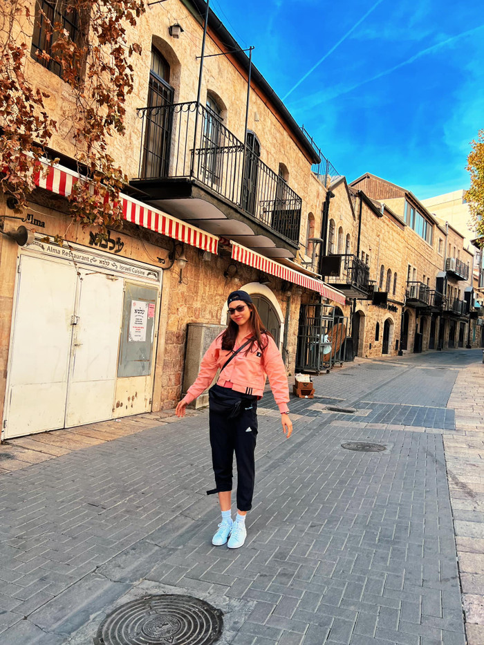 Người đẹp sinh năm 1988 chọn đồ thể thao, phóng khoáng trẻ trung tạo dáng tại không gian mang đậm dấu ấn thời gian của thành phố cổ Jerusalem.