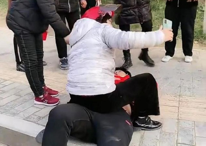 Người phụ nữ trung niên ngồi đè lên người nam thanh niên rồi livestream. 