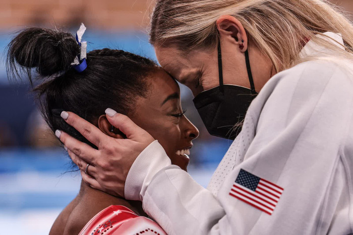 Vận động viên thể dục dụng cụ người Mỹ Simone Biles được huấn luyện viên Cecile Canqueteau-Landi chúc mừng sau khi biết Biles sẽ giành huy chương Olympic trong trận chung kết xà thăng bằng. Biles đã rút khỏi một số sự kiện trước đó ở Tokyo, với lý do lo ngại về sức khỏe tâm thần.