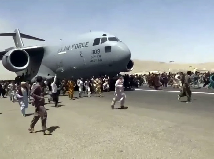 Người Afghanistan đuổi theo một máy bay vận tải của Không quân Mỹ trên đường băng của sân bay quốc tế Kabul. Video cho thấy những người bám vào thân máy bay khi nó sắp cất cánh. Một ngày sau khi Taliban tiếp quản Afghanistan, hàng trăm người đã đổ lên đường băng, tuyệt vọng tìm đường thoát khỏi đất nước dưới tay phiến quân.