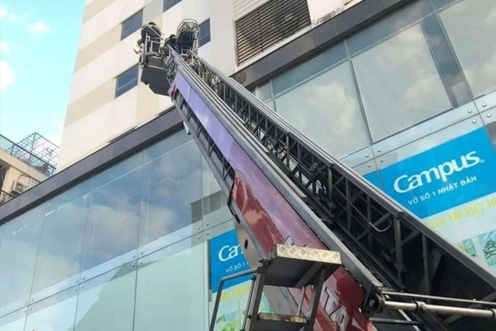 Lực lượng chức năng dùng xe cẩu để tiếp cận vị trí cháu bé rơi. Ảnh: Lao Động