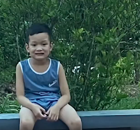 Bé trai đã hé miệng cười rất lâu kể từ khi nghe lời dọa của chị gái. Ảnh cắt từ clip