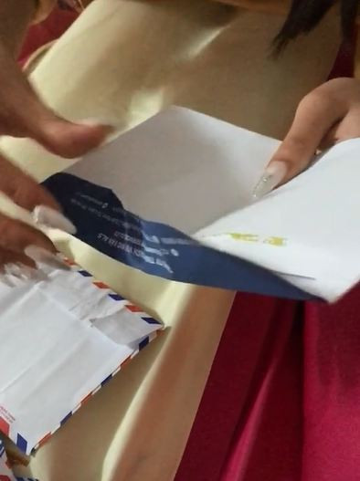 Chú rể nhờ cô dâu bóc phong bì của bạn mừng cưới giúp mình. 