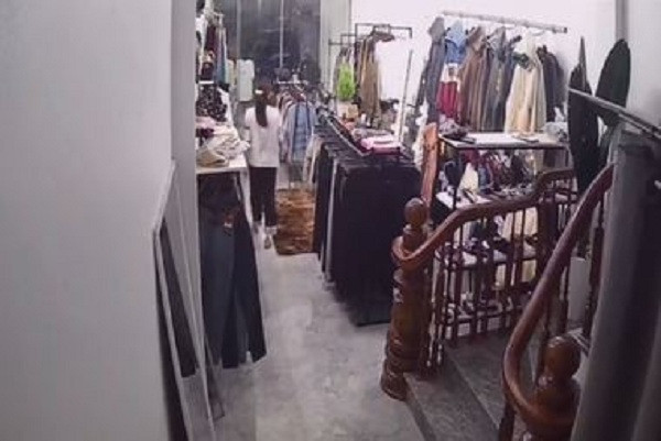 Nữ nhân viên ra ngoài đón khách nam vào xem cửa hàng.