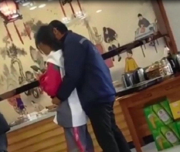 Cô gái bị người đàn ông trung niên ôm ấp thân mật trong cửa hàng.&nbsp;