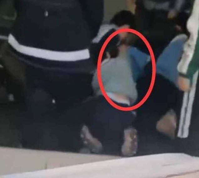 Nam sinh bị các bạn học đè xuống nền nhà, tụt quần. 