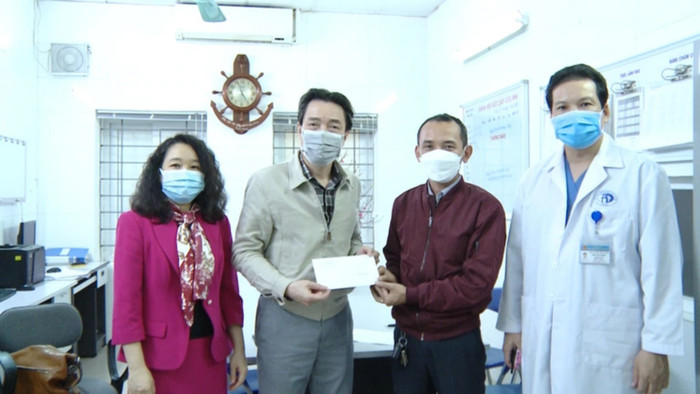 Cục trưởng Cục trẻ em Đặng Hoa Nam (thứ hai từ trái sang) trao quà giúp bé gái 3 tuổi điều trị tại bệnh viện Xanh Pôn. (Ảnh: Dân Trí).