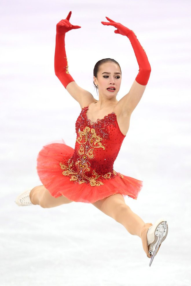 Alina Zagitova mặc trang phục màu đỏ nổi bật trên nền băng trắng tại thế vận hội Pyeongchang 2018.