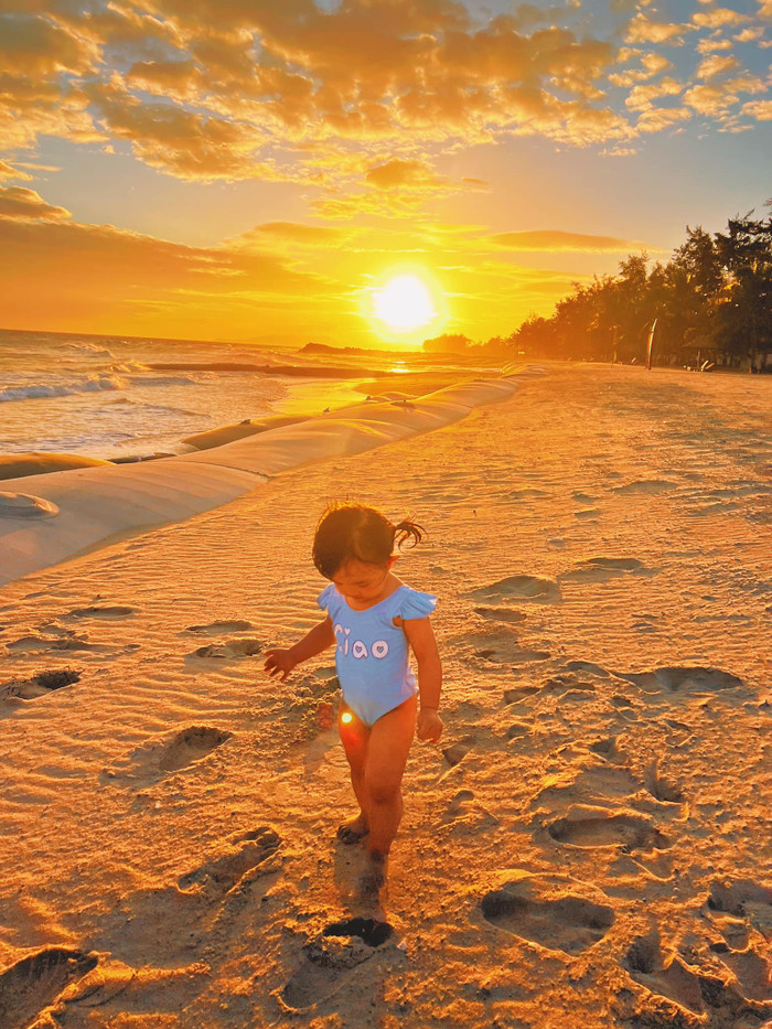 Khoảnh khắc cực đẹp của Winnie bên bãi biển với mặt trời lặn phía sau.