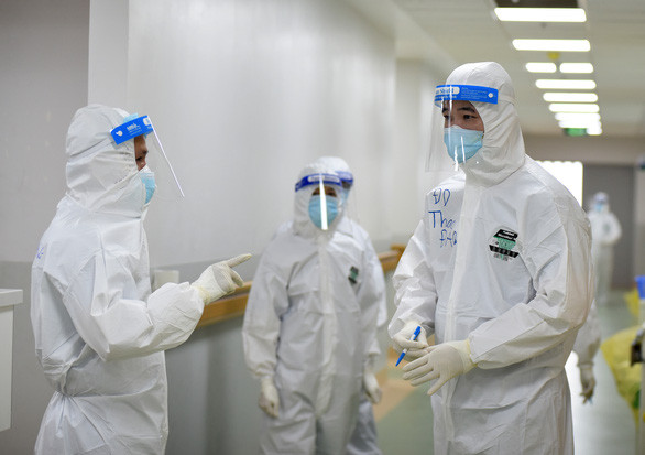 Nhân viên trạm y tế lưu động phường 11, quận Tân Bình thăm hỏi và phát thuốc cho các F0 điều trị tại nhà - Ảnh: DUYÊN PHAN