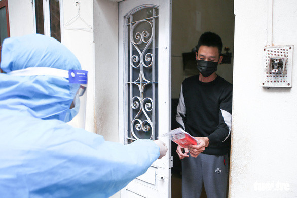 Một bệnh nhân F0 nhận túi thuốc gói A gồm các loại thuốc hạ sốt, vitamin để tăng sức đề kháng ở Hà Nội - Ảnh: HÀ QUÂN