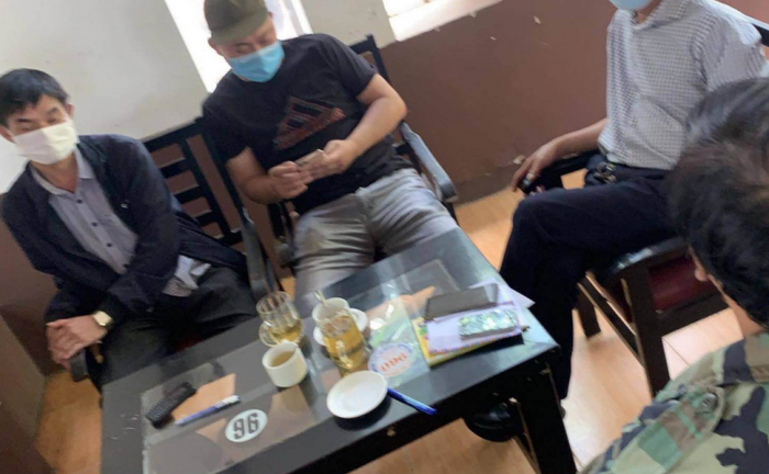 Nhóm đối tượng bị bắt quả tang khi đang nhận tiền từ bà T. Ảnh: CAND