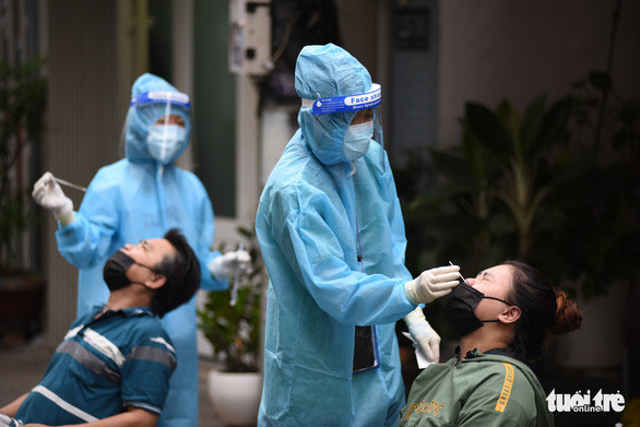 Lấy mẫu xét nghiệm COVID-19 cho người dân nằm trong vùng đỏ ở phường 3, quận Bình Thạnh, TP.HCM - Ảnh: DUYÊN PHAN