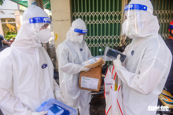 Nhân viên y tế phát thuốc cho F0 điều trị tại nhà ở quận 8, TP.HCM - Ảnh: QUANG ĐỊNH