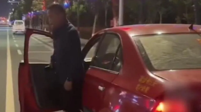 Người đàn ông bước ra khỏi chiếc ô tô đỏ.