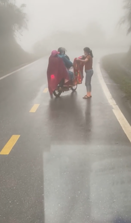 Anh Quang Sao và người phụ nữ đi cùng đã khoác một tấm chăn cho cháu bé đỡ lạnh.