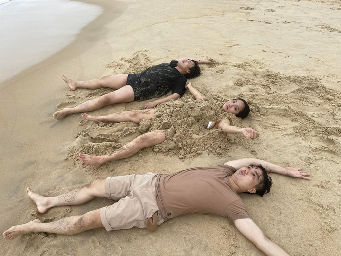 MC Cát Tường gây sốt khi nằm cùng hai người đàn ông ở bãi biển Ảnh 1