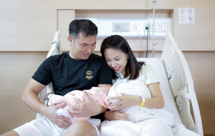 Vân Hugo và ông xã bên cạnh nhóc tỳ vừa chào đời.