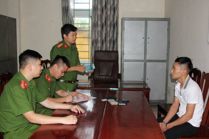 Cán bộ điều tra lấy lời khai của đối tượng  Ngô Quang Tứ. Ảnh: CAND