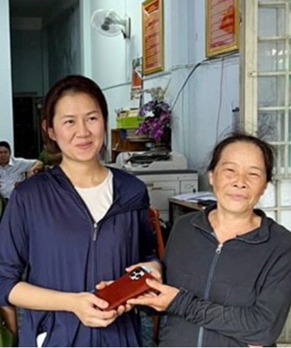 Bà Hoa (áo đen, phải) trao trả lại chiếc iPhone đắt tiền cho chủ nhân. Ảnh: CAO