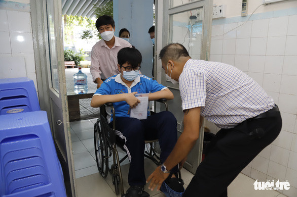 Cán bộ ở điểm thi hỗ trợ em Trần Dương Lê. Nguồn ảnh: Tuổi trẻ online