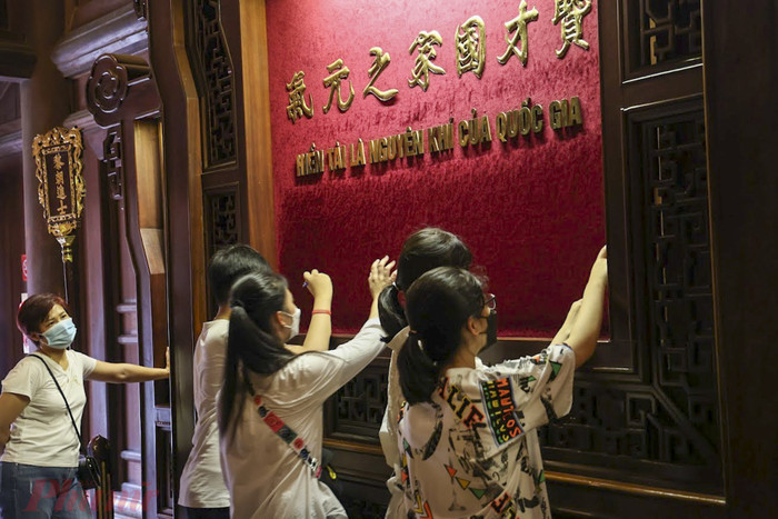 Không chỉ có các phụ huynh, học sinh mà các giáo viên cũng đến Văn Miếu cầu nguyện cho học trò của mình. Ảnh: Báo Phụ Nữ.